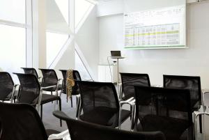a meeting room with black chairs and a screen at Scandic Victoria Tower in Stockholm