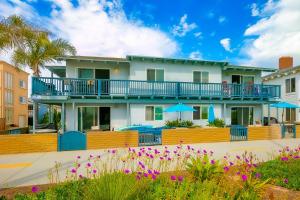 Casa con balcón con mesas y sombrillas en Groundswell B, en Newport Beach