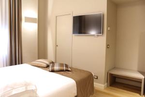 a bedroom with a bed and a tv on the wall at Best Western Hotel Moderno Verdi in Genova