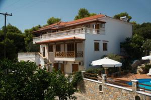 a large white house with a swimming pool in front of it at Elena Studios in Patitiri