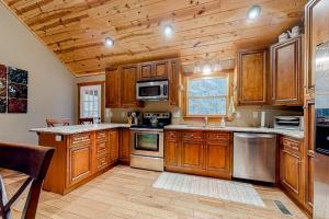 eine Küche mit Holzschränken und einer Holzdecke in der Unterkunft Wandering Bear's Den in Ellijay