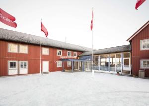 ein rotes Gebäude mit Flaggen davor in der Unterkunft Scandic Svolvær in Svolvær
