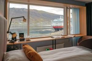 a bedroom with a window with a cruise ship in the water at Scandic Ishavshotel in Tromsø