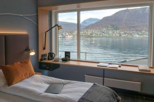 a bedroom with a desk and a bed with a window at Scandic Ishavshotel in Tromsø