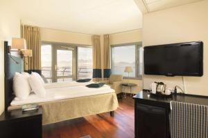 um quarto de hotel com uma cama grande e uma televisão em Scandic Seilet Hotel em Molde