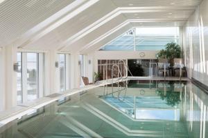 a swimming pool in a house with a large window at Scandic Hell in Hell