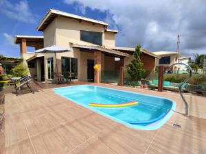 a swimming pool in front of a house at Linda casa de praia em Aracaju! in Aracaju