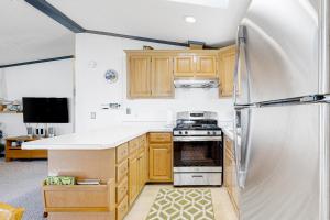 a kitchen with wooden cabinets and a stainless steel refrigerator at Assateague Point - Bay Breeze in Berlin