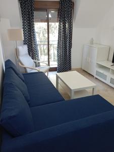 uma sala de estar com um sofá azul e uma mesa em Apartamento en Monachil pueblo em Monachil