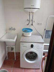 een wasmachine in een badkamer met een wastafel bij Apartamento en Monachil pueblo in Monachil