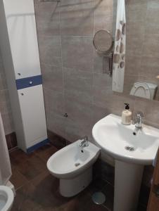 een badkamer met een wastafel, een toilet en een spiegel bij Apartamento en Monachil pueblo in Monachil