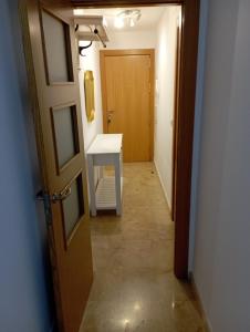 a hallway with a white table and a door at Apartamento en Monachil pueblo in Monachil