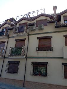 um edifício com janelas com barras e varandas em Apartamento en Monachil pueblo em Monachil