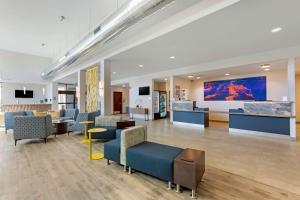 a lobby with chairs and tables and a large screen at Best Western Plus Executive Residency Phoenix North Happy Valley in Phoenix