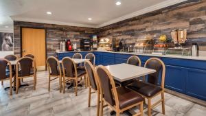 a restaurant with blue cabinets and a table and chairs at SureStay Plus by Best Western Benbrook Fort Worth in Fort Worth