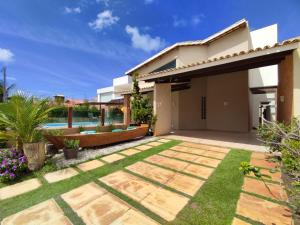 a backyard with a pool and a house at Linda casa de praia em Aracaju! in Aracaju