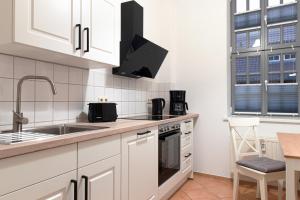 a kitchen with white cabinets and a sink at Ferienwohnungen BUNTER HOF Quedlinburg in Quedlinburg