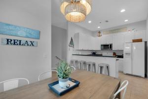 a kitchen and dining room with a table with a potted plant at Emerald Coast Cabana in Panama City Beach