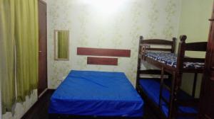 a bedroom with two bunk beds and a window at Quitinete Cabo Frio , 300 metros da Praia do Forte in Cabo Frio