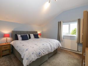 a bedroom with a large bed and a window at The Cider Shed in Winscombe