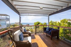 een balkon met stoelen en uitzicht op de oceaan bij BEST OCEAN VIEWS ON STRADDIE + SUNSET DECK in Point Lookout
