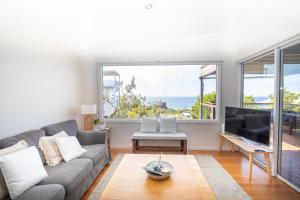sala de estar con sofá y ventana grande en BEST OCEAN VIEWS ON STRADDIE + SUNSET DECK en Point Lookout