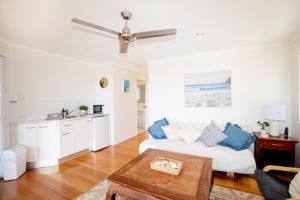 sala de estar con sofá blanco y mesa en BEST OCEAN VIEWS ON STRADDIE + SUNSET DECK en Point Lookout
