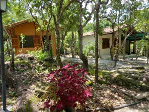 uma casa com flores cor-de-rosa em frente em Chalés Santo Verde em Goiás