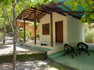 Eine Katze, die auf der Veranda eines Hauses sitzt in der Unterkunft Chalés Santo Verde in Goiás