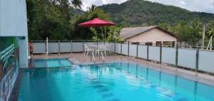 una piscina con ombrellone e tavolo e sedie di Hotel Green View Buttala a Buttala