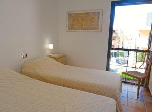 - une chambre avec deux lits, une fenêtre et une chaise dans l'établissement Casa Seagulls, à Altea