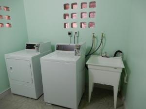 a bathroom with two washing machines and a sink at Oistins Bayview Apartments in Christ Church