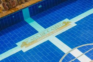 a swimming pool with a sign in the water at Casa de Campo Hotel & Spa in Villa de Leyva