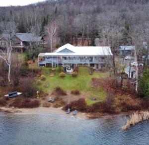 an aerial view of a large house on an island in the water at Le Lodge du lac in Saint-Faustin