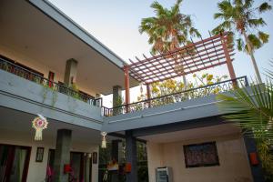 a balcony on the side of a building with palm trees at Anik Homestay in Canggu