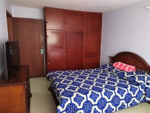 Un dormitorio con una cama azul y blanca y un tocador en Hermoso apartamento en Pasto. Central parque San Andrés, en Pasto