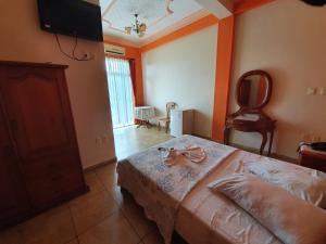 a bedroom with a bed and a flat screen tv at Hotel El Cristo in Cobija