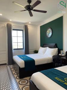a bedroom with two beds and a ceiling fan at Selecthotel Hạ Long in Ha Long