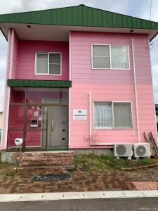 a pink house with a green roof at Cozy Penguin House Bibai in Bibai