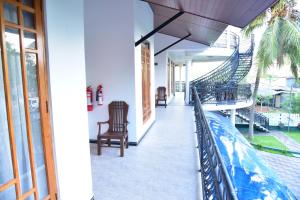 L S Lanka Boutique Hotel في دامبولا: شرفة منزل مع كراسي وسياج