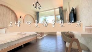 Dormitorio con cama, escritorio y TV en Angel Inn, en Hualien City