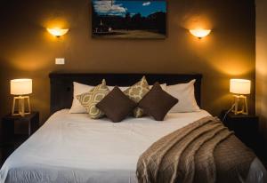 ein Schlafzimmer mit einem Bett mit Kissen und zwei Lampen in der Unterkunft PRECIOSA VILLA FRENTE AL MAR in Celestún