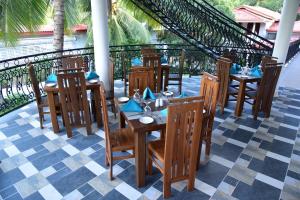 L S Lanka Boutique Hotel في دامبولا: مطعم بطاولات وكراسي خشبية على فناء