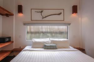 a bedroom with a white bed with a window at Sarina Hotel & Villa in Phnom Penh