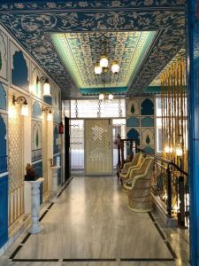 a hallway with blue walls and a ceiling with chairs at All Seasons Homestay in Jaipur