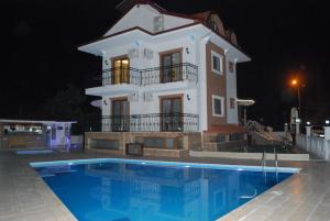 a house with a swimming pool in front of a building at Funda Hotel in Göcek
