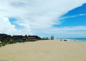 a sandy beach with a view of the ocean at Waves Beach House in Puducherry