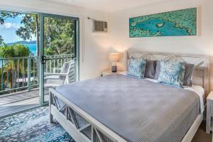 ハミルトン島にあるSunset Waters 12 on Hamilton Island by HamoRentのベッドとバルコニーのある寝室
