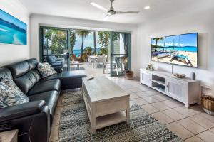 a living room with a couch and a table at Sunset Waters 12 on Hamilton Island by HamoRent in Hamilton Island