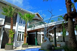 a house with palm trees in front of it at Oxville Hotel in Padang